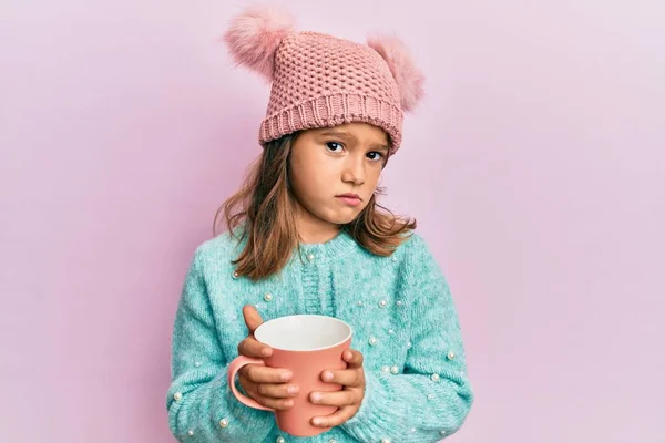 Kleine Schöne Mädchen Mit Rosa Becher Trägt Niedliche Wollmütze Skeptisch — Stockfoto