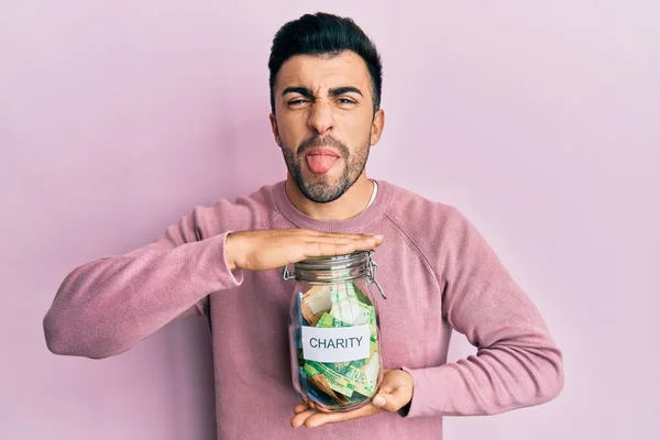 Jovem Hispânico Homem Segurando Frasco Caridade Com Dinheiro Furando Língua — Fotografia de Stock