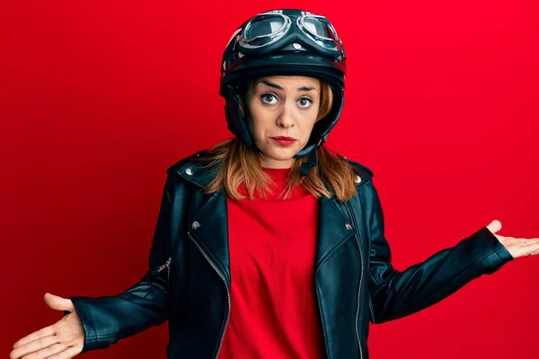 オートバイのヘルメットを身に着けているヒスパニック系の若い女性は腕や手で混乱した表現を調達した 疑わしい概念 — ストック写真