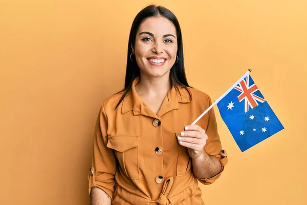 若いですブルネット女性を保持しているオーストラリアのフラグ見て正と幸せな立ちと笑顔で自信を持って笑顔示す歯 — ストック写真
