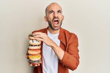 Genç İspanyol adam elinde lezzetli renkli çöreklerle öfkeli ve kızgın çığlıklar atıyor öfkeyle bağırıyor, öfkeyle yukarı bakıyor.. 