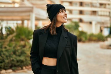 Genç İspanyol kadın parkta mutlu bir şekilde gülümsüyor..