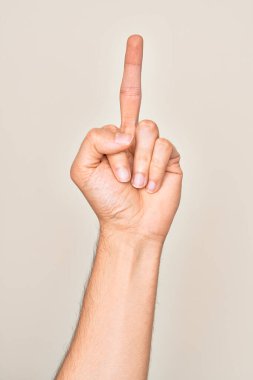 Hand of caucasian young man showing fingers over isolated white background showing provocative and rude gesture doing fuck you symbol with middle finger
