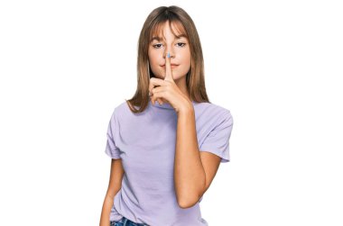 Kafkasyalı, günlük kıyafetler giyen genç bir kız. Dudakları parmaklarıyla sessiz olmak istiyor. sessizlik ve gizli konsept. 