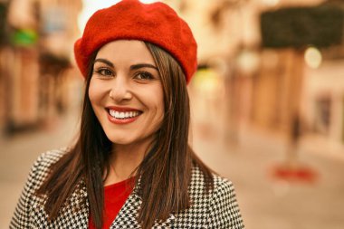 Genç İspanyol kadın gülümseyerek şehirde mutlu mesut dikiliyor..