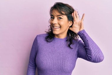 Günlük kıyafetler giyen, ağzı kulaklarında gülümseyen dedikoduları ve dedikoduları dinleyen genç İspanyol kadın. Sağırlık kavramı. 