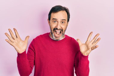 Orta yaşlı İspanyol bir adam gündelik kıyafetler giyip çılgınlığı kutluyor ve başarıya hayret ediyor. Kolları açık, gözleri açık, heyecanlı çığlıklar atıyor. Kazanan konsept 