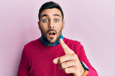 Gündelik kıyafetler giyen genç İspanyol adam kameraya kızgın ve sinirli bir şekilde seni işaret ediyor. 