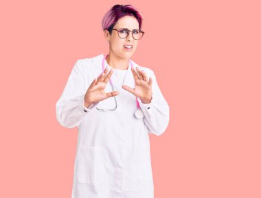 Pembe saçlı, doktor üniforması giyen genç ve güzel bir kadın tiksinti ifadesi takınıyordu. Tiksinti reaksiyonu yüzünden tiksinti ve korku ifadesi takınıyordu. Eller havada. 