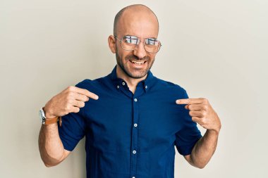 Gündelik kıyafetler ve gözlük takan, kendine güvenen, gülümseyen, kendini gururlu ve mutlu gösteren İspanyol genç bir adam.. 