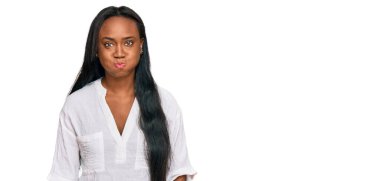 Sıradan kıyafetler giyen, komik yüzlü, yanakları şişen genç siyahi bir kadın. Havayla şişmiş ağız, çılgın bir ifade.. 