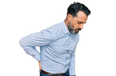 Orta yaşlı, sakallı, iş gömleği giyen sırt ağrısı çeken, elleriyle dokunan, kas ağrısı çeken bir adam. 