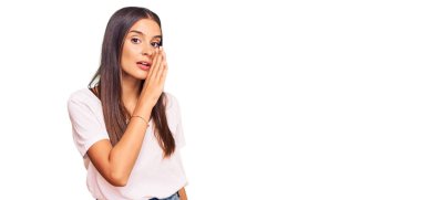 Latin kökenli genç bir kadın, el pençe dize giyinmiş, gizli söylentiler yayıyor, kötü niyetli konuşmalar fısıldıyor. 