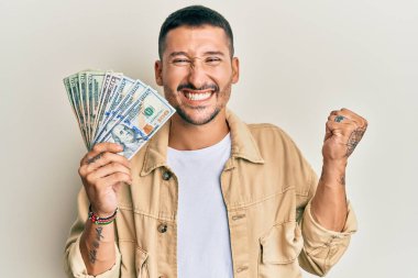 Dövmeleri olan yakışıklı bir adam gururla bağırıyor zaferi ve başarıyı kutluyor. 