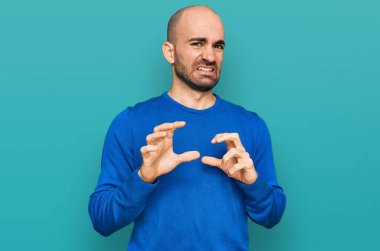 Gündelik kıyafetler giyen genç İspanyol adam tiksinti ifadesi takındı, tiksinti tepkisi yüzünden tiksinti ve korku dolu bir ifade takınıyordu. Eller havada. 