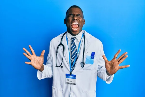 身穿医生制服的年轻的非洲裔美国人 高举双臂 闭上眼睛 兴奋地欢呼着 庆祝着成功的疯狂和疯狂 获奖者概念 — 图库照片