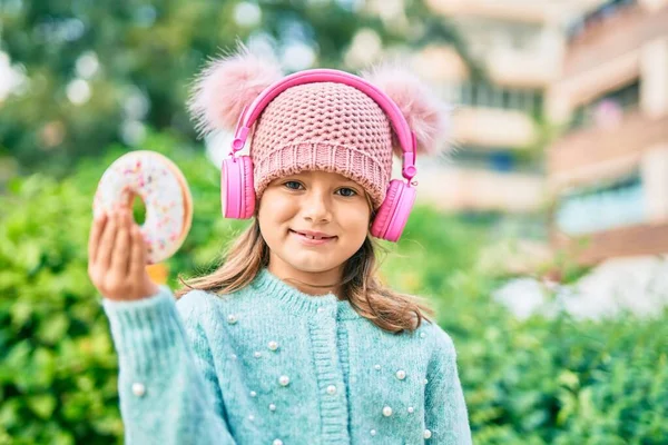 Entzückende Kaukasische Kindermädchen Mit Kopfhörern Und Donut Essen Park — Stockfoto