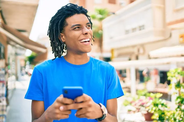 Młody Afrykanin Uśmiecha Się Szczęśliwy Korzystając Smartfona Ulicy Miasta — Zdjęcie stockowe
