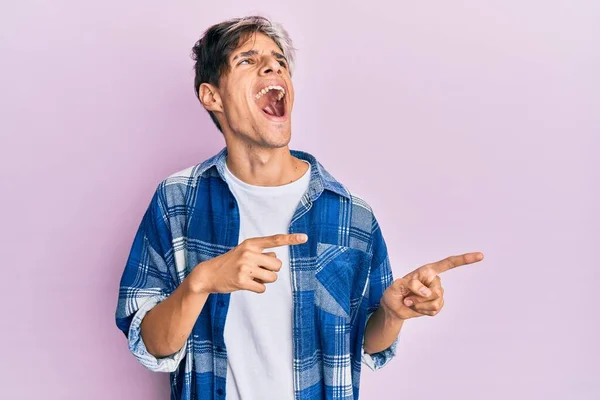 Joven Hombre Hispano Señalando Con Los Dedos Hacia Lado Enojado —  Fotos de Stock