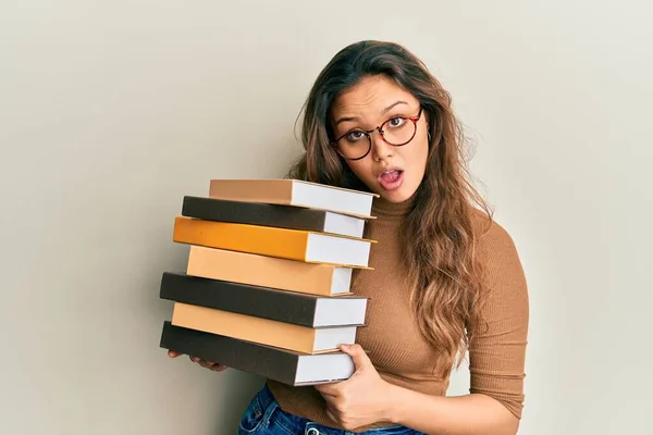 Ung Spansktalende Pige Holder Bunke Bøger Chok Ansigt Ser Skeptisk - Stock-foto