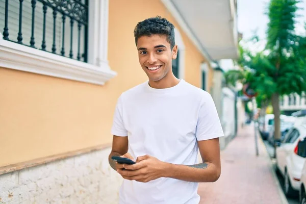 Genç Latin Adam Mutlu Bir Şekilde Gülümsüyor Şehirde Akıllı Telefon — Stok fotoğraf