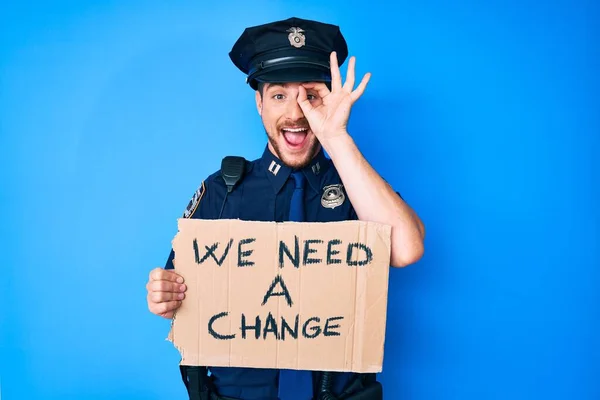 Młody Biały Mężczyzna Noszący Policyjny Mundur Trzymający Potrzebujemy Zmiany Transparentu — Zdjęcie stockowe