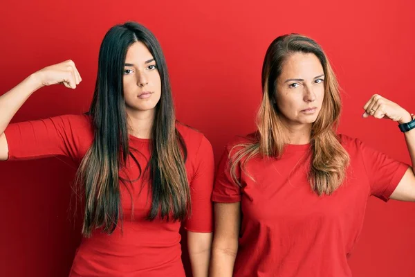 Família Hispânica Mãe Filha Vestindo Roupas Casuais Sobre Fundo Vermelho — Fotografia de Stock