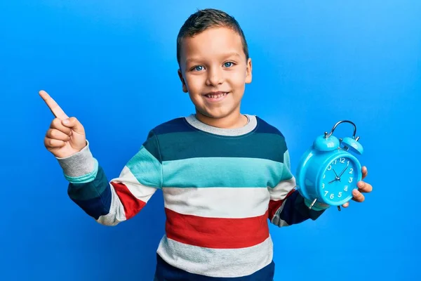 Bambino Bambino Tenendo Sveglia Sorridente Felice Puntando Con Mano Dito — Foto Stock