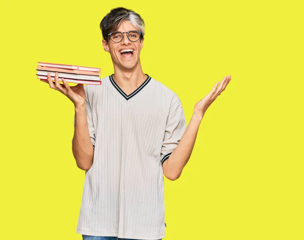 Jeune Homme Hispanique Tenant Des Livres Célébrant Victoire Avec Sourire — Photo