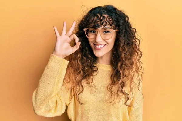 Młoda Latynoska Dziewczyna Luźnych Ubraniach Okularach Robi Znak Palcami Uśmiechając — Zdjęcie stockowe