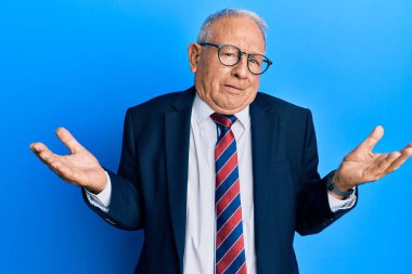 İş elbisesi giymiş, kravatını takmış, kolları açık ve kafası karışmış, hiçbir fikri olmayan beyaz bir adam.. 