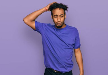 Sakallı, sıradan mor tişörtlü, Afro-Amerikalı genç bir adam soru sorup kafasını karıştırıyor. Şüpheyle kararsız, kafa kafaya düşünerek. Düşünceli kavram. 
