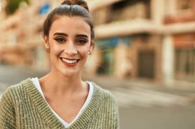 Güzel esmer kadın güler yüzlü mutlu ve kendinden emin sonbaharın güneşli bir gününde şehirde.