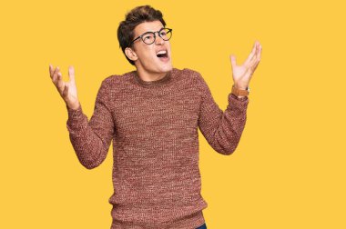 Yakışıklı beyaz adam, sıradan süveter giyiyor ve gözlük takıyor. Deli gibi bağırıyor ve bağırıyor. Saldırgan bir ifade ve kollar havada. hüsran kavramı. 