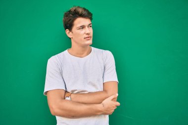 Şehrin duvarına yaslanmış, ciddi bir suratı olan beyaz bir genç..