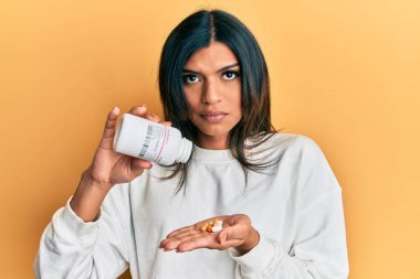 Genç Latin transseksüel kadın elinde haplar tutuyordu. Depresyondaydı ve üzüntüden ağlıyordu. Kızgın ve korkmuştu. hüzünlü ifade. 