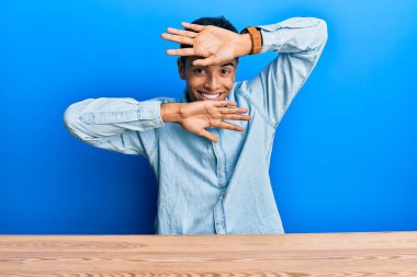 Genç, yakışıklı, Afro-Amerikan bir adam, gündelik giysiler içinde masaya oturmuş gülümseyen, neşeli bir şekilde ellerini göstererek dikizleyerek bön bön bakıyor. Şaşırdım ve çıktım. 