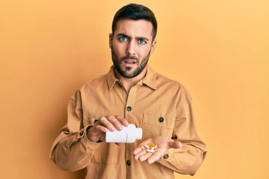 Genç İspanyol adamın elinde haplardan bihaber ve kafası karışmış bir ifade vardı. şüphe kavramı. 