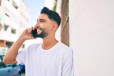 Şehirdeki akıllı telefondan konuşan, ciddi bir suratı olan genç bir Arap..