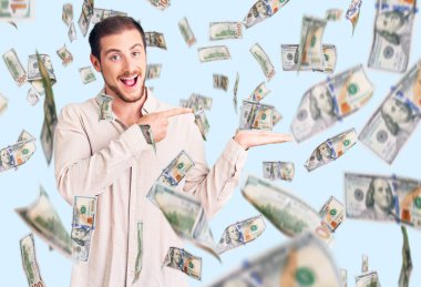 Genç, beyaz, sıradan kıyafetler giyen yakışıklı bir adam kameraya hayret ediyor ve gülümsüyor..