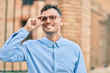 Genç İspanyol işadamı gülümseyerek şehirde bardaklarına dokunuyor..