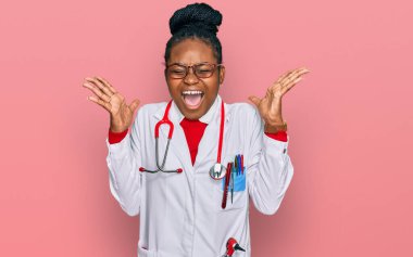 Genç Afro-Amerikan kadın doktor üniforması giyiyor ve steteskop başarıyı kollarını kaldırıp heyecanla haykırarak deli ve deli bir şekilde kutluyor. Kazanan konsept 