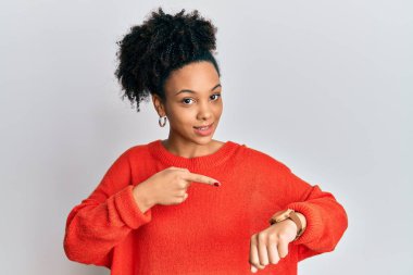 Gündelik giysiler giyen genç Afro-Amerikalı kız, saati izlemek için acele ediyor, sabırsızlanıyor ve geç kaldığı için kızgın. 