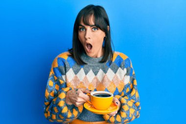 Bir fincan kahve içen genç İspanyol kadın şaşkınlık ve şaşkınlık dolu bir ifade, korku ve heyecanlı bir yüz ifadesiyle şoka girdi.. 