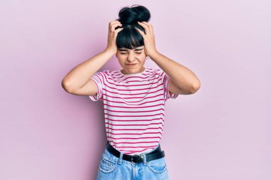 Genç İspanyol kız gündelik kıyafetler giyiyor. Baş ağrısı çekiyor. Acı ve migren yüzünden çaresiz ve stresli. Eller başının üstünde.. 