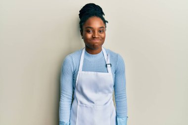 Saçları örgülü, daha temiz önlük takan, eldivenli, komik yüzlü Afro-Amerikalı bir kadın. Havayla şişmiş ağız, çılgın bir ifade.. 