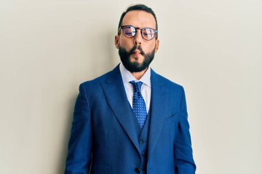 Sakallı, takım elbiseli ve kravatlı genç adam dudaklarıyla balık suratı yapıyor, çılgınca ve komik bir jest. Komik ifade. 
