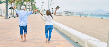 Orta yaşlı İspanyol çift gülümseyerek gezinti güvertesinde mutlu mesut yürüyor.