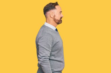 İş elbiseleri giyen yakışıklı orta yaşlı bir adam. Taraf arıyor, profil pozu veriyor. Doğal bir yüzü ve kendine güvenen bir gülümsemesi var.. 