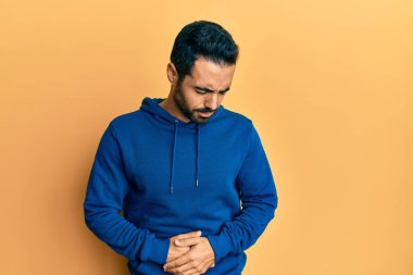 hazımsızlık, acı verici bir hastalık ve midesi kötü hissettiği için günlük giysiler giyen genç İspanyol bir adam. Ağrı kavramı. 